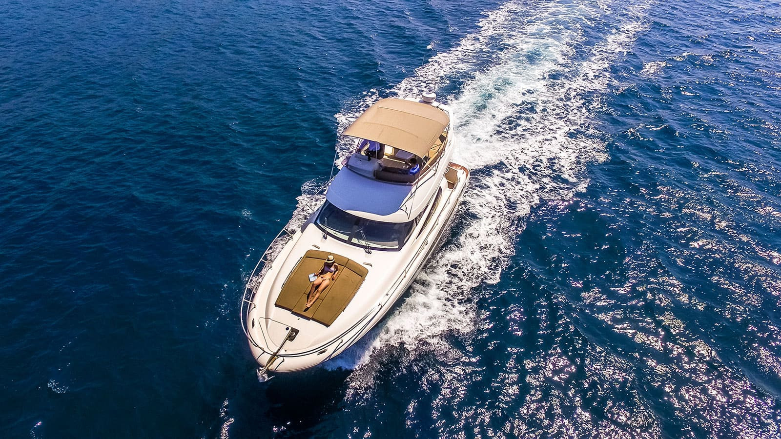 Bird’s eye view of a Prestige 440 cruising the Adriatic sea with a woman sunbathing on the sun deck