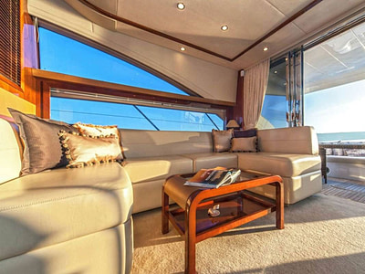 Indoor lounge area with leather couch on motor yacht