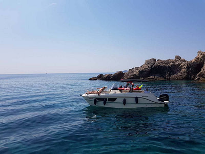quicksilver 805 speedboat with two men on board, near an island