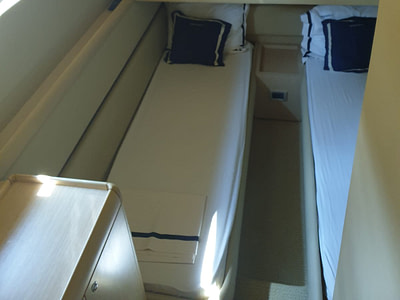 A cabin with two single beds onboard a Ferretti 591 yacht